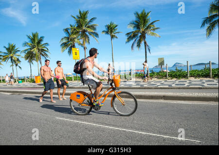 RIO DE JANEIRO - 6. März 2016: Brasilianer gehen und Reiten Fahrräder entlang der Strand von Ipanema Strand Straße Avenida Vieira Souto. Stockfoto