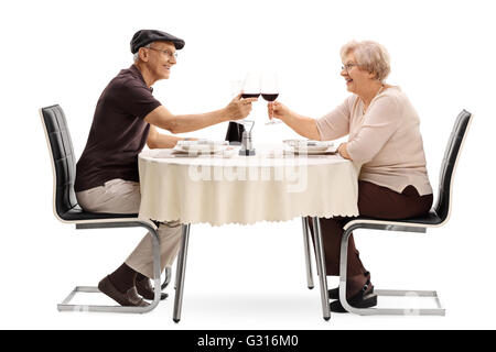 Älteres Ehepaar, einen Toast mit Rotwein setzte auf ein romantisches Rendezvous isoliert auf weißem Hintergrund Stockfoto