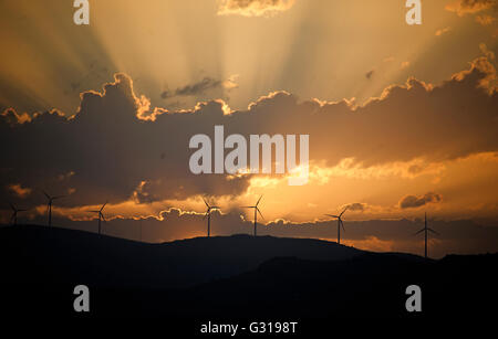 Sonnenuntergang über den Hügeln rund um Trogir in Kroatien mit Silhouetten der Windkraftanlagen Stockfoto