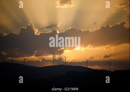 Sonnenuntergang über den Hügeln rund um Trogir in Kroatien mit Silhouetten der Windkraftanlagen Stockfoto