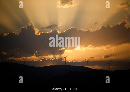 Sonnenuntergang über den Hügeln rund um Trogir in Kroatien mit Silhouetten der Windkraftanlagen Stockfoto