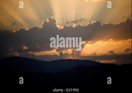 Sonnenuntergang über den Hügeln rund um Trogir in Kroatien mit Silhouetten der Windkraftanlagen Stockfoto