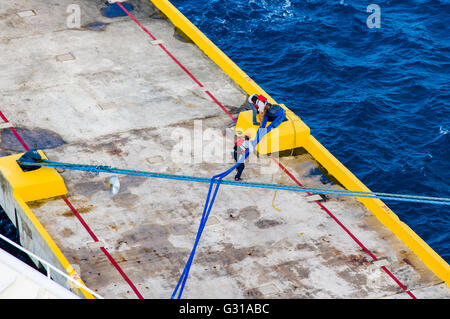 Crew-Mitglieder ziehen in die Seile sichern Kreuzfahrtschiff Vision der Meere zum Pier an der Costa Maya, Mexiko Stockfoto