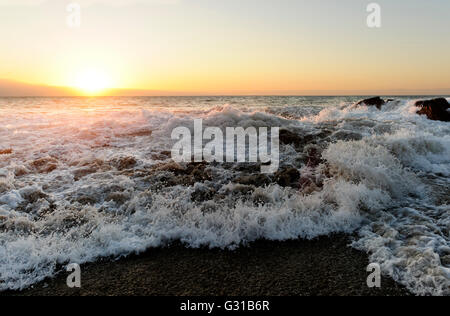 Wellen, ist ein Ozean Seelandschaft mit einer Welle stürzt gegen einen Felsen Wasser in die Luft zu werfen. Stockfoto