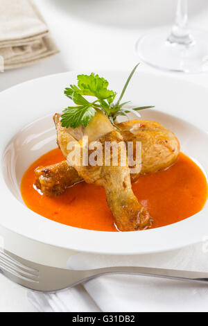 Zwei gebratene Hähnchenschenkel in einer Paprika-Sauce. Stockfoto