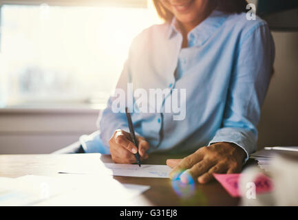 Detailansicht der Hände auf Umschlag mit warmen Sonnenlicht durch Fenster schreiben Stockfoto