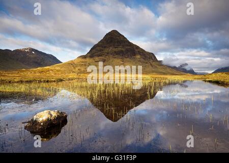 Farbfoto der Buachaille Etive Beag während der Sommerpause bei Sonnenaufgang mit stillem Wasserreflexionen in man Na Fola Glencoe nehmen Stockfoto