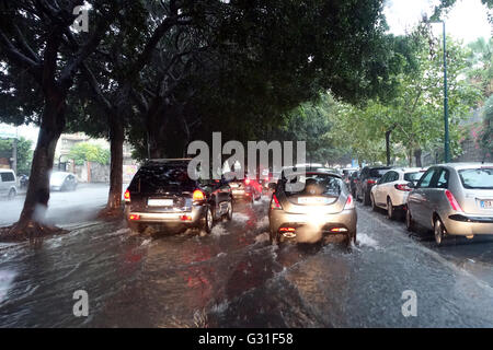 Aci Trezza, Italien, Autos fahren auf einer überfluteten durch Regenwasser Street Stockfoto