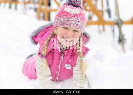 kleine Mädchen glücklich zu spielen im Schnee Stockfoto