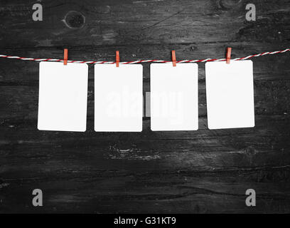 Leeres Papier oder Foto Rahmen rot gestreiften Wäscheleine hängen. Hölzerne Hintergrund. Vorlage für Ihren Text. Stockfoto