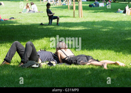 Ein Paar, das sich im Hyde Park, City of Westminster, London, England, Großbritannien sonnt Stockfoto