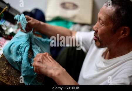 (160606)--TIANJIN, 6. Juni 2016 (Xinhua)--Schatten Marionette Künstler Zhang Kui speichert Papier Schatten Marionette Zunftdenkmäler in einem Paket in Tianjin, Nord-China, 5. Juni 2016. Zhang Kui, geboren 1937, ist jetzt eine Erbin der Schattenfiguren. Er hat hing von Schattenspielfiguren für 68 Jahre seit seiner Kindheit gelebt durchführen. "Mein Vater hatte 38 Schattenkästen, mein Bruder durchgeführt und ich schnitzte die Schattenfiguren," sagte der Erbe wenn er seiner Kindheit erinnert. Heute, wie wenige Leute die Schatten-Marionette-Leistung. Zhang Kui hatte einmal zwei Lehrlinge, aber beide schließlich aufgegeben und Auto Stockfoto