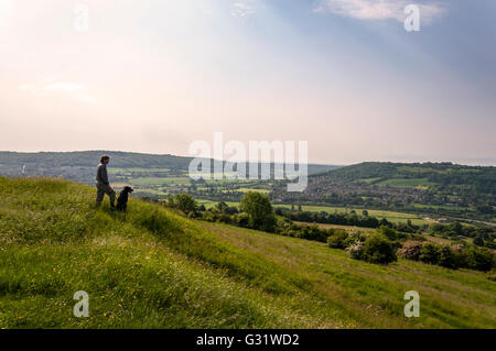 Furnished, Somerset, Großbritannien Wetter. 6. Juni 2016. Eine Dogwalker nimmt in der Ansicht von oben auf die alte Festung der Eisenzeit auf wenig Solsbury Hill an einem warmen, feuchten Sommermorgen. Foto: Credit: Richard Wayman/Alamy Live-Nachrichten Stockfoto