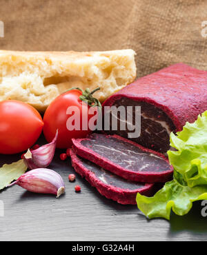 Jerky in Gewürzen mit Brot und Gemüse Stockfoto