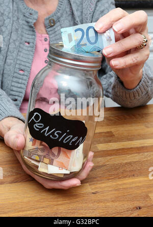 Eine ältere Frau mit Geld gefüllt Glas gekennzeichnet mit dem niederländischen Wort für Rente Stockfoto