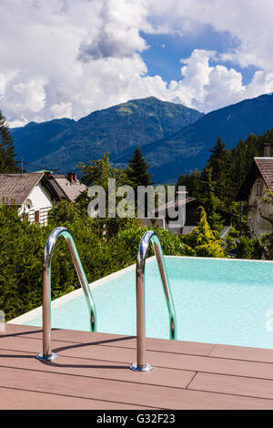 Schnappen Sie sich Bars Leiter in blauen Swimmingpool in einem Garten in Österreich Stockfoto