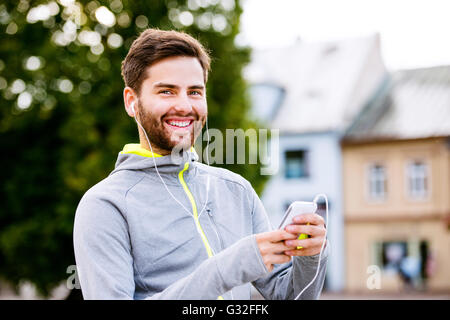 Junge Hipster Läufer in der Stadt mit smartphone Stockfoto