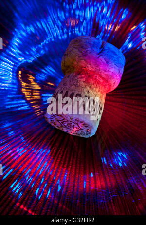 Sektkorken auf der Tanzfläche der Party-Disco mit mehrfarbiger Beleuchtung für besondere Veranstaltungen. Französischer Sekt Stockfoto