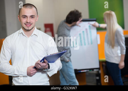 Porträt eines Mitarbeiters junge selbstbewusste Männer gekleidet in Freizeitkleidung auf digital-Tablette stehend im modernen Büro spa Stockfoto