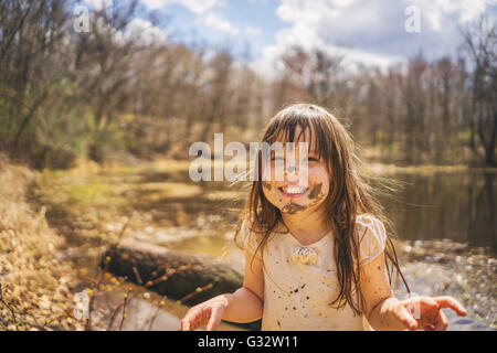 Porträt eines Mädchens mit Schlamm auf dem Gesicht lachend, USA Stockfoto