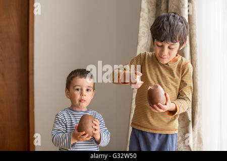 Zwei jungen essen große Schokoladeneier Stockfoto