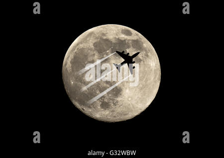 Silhouette von einem Flugzeug Seitensprung vor der Mond Stockfoto