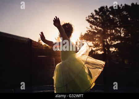 Mädchen drehte sich um im Garten bei Sonnenuntergang Stockfoto