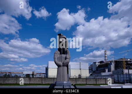 Ein Denkmal für Reaktorunfall von Tschernobyl 1986 neben der konkreten Sarkophag über dem beschädigten Reaktor 4 des ehemaligen Kernkraftwerks befindet sich in der Sperrzone von Tschernobyl in der Ukraine am 4. Juni 2016. Der Unfall von Tschernobyl ereignete sich am 26. April 1986 im Kernkraftwerk Tschernobyl in der Stadt Pripjat und war der schlimmsten Kernkraft Werk Unfall in der Geschichte in Bezug auf Kosten und Verluste. Stockfoto