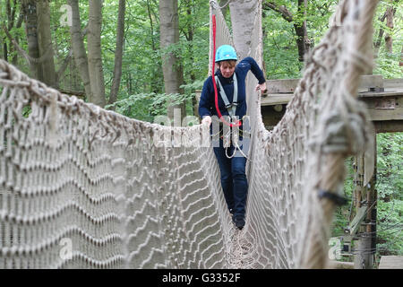 Potsdam, Deutschland, klettert Frau in einem Hochseilgarten Stockfoto