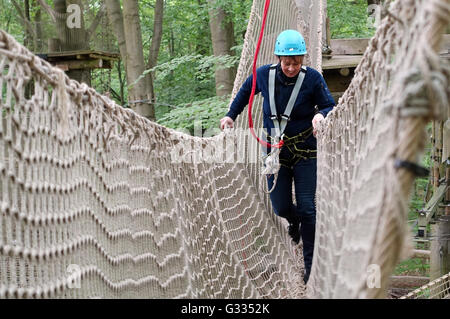 Potsdam, Deutschland, klettert Frau in einem Hochseilgarten Stockfoto