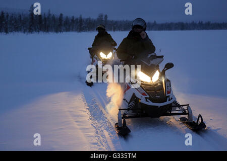 ? K skero, Finnland, Männer sind in der Nacht auf Motorschlitten fahren Stockfoto