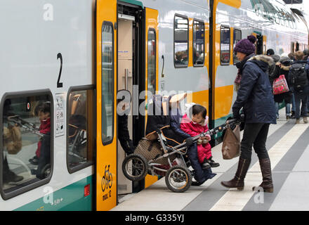 Berlin, Deutschland, heben Sie Eltern einen Kinderwagen in einen Zug der ODEG Stockfoto