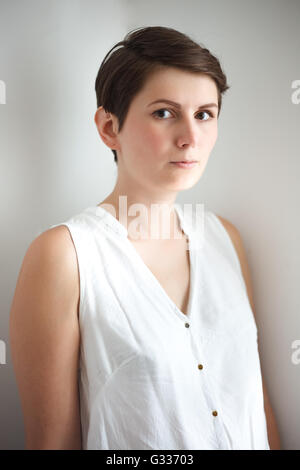 Charmante Kurzhaar junge Frau ohne Make-up auf weißem Hintergrund Stockfoto