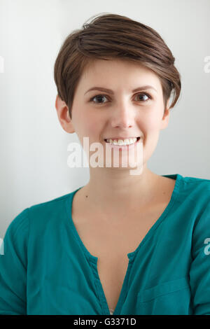 Charmante kurzhaarige Frau ohne Make-up auf weißem Hintergrund Stockfoto