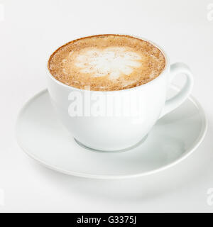 Leckeren Cappuccino in einer weißen Tasse auf dem Teller auf weißem Hintergrund. Schließen Sie die Seitenansicht. Stockfoto