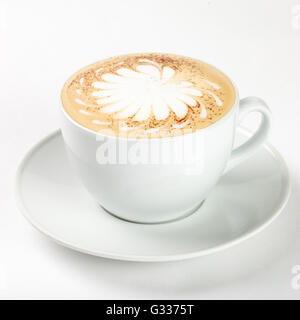 Leckeren Cappuccino in einer weißen Tasse auf dem Teller auf weißem Hintergrund. Schließen Sie die Seitenansicht. Stockfoto