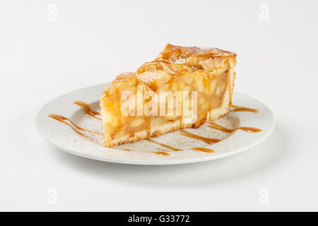 Leckere Apfelkuchen Charlotte mit Karamell auf dem Teller auf weißem Hintergrund. Schließen Sie die Seitenansicht. Stockfoto