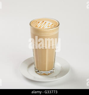Leckeren Latte in ein hohes Glas auf dem Teller auf weißem Hintergrund. Stockfoto