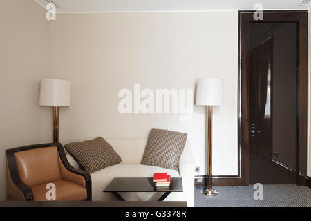 luxuriöse Raum für Entspannung und Erwartungen. Leder-Sofa, Couchtisch und Stehleuchte. Stockfoto