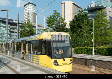 Metrolink Straßenbahn zieht in der MediaCity Haltestelle MediaCityUK im Bereich der Greater Manchester Salford Quays Stockfoto