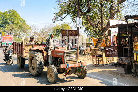 Mann, der Orange das Abschleppen des Schleppers Trailer mit Passagieren, Agra, Uttar Pradesh, Indien, Asien Stockfoto