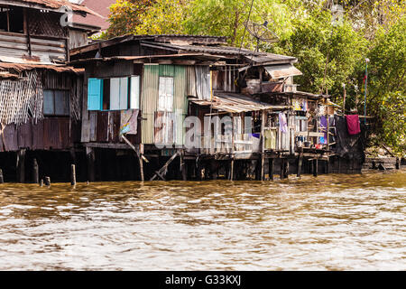 Hölzerne Slums auf Stelzen am Ufer des Chao Praya River in Bangkok, Thailand Stockfoto