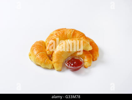 Marmelade gefüllte Croissants und die Schüssel mit Erdbeermarmelade auf weißem Hintergrund Stockfoto