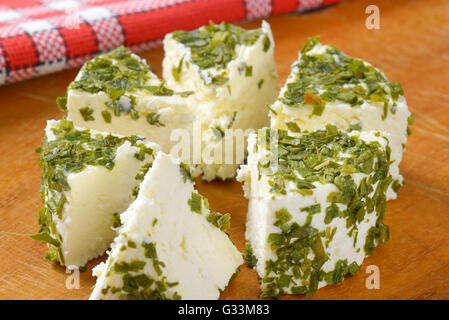 Nahaufnahme von Schnittkäse mit Schnittlauch auf Holzbrett Stockfoto