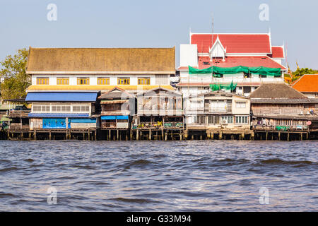 Bunte Häuser auf Stelzen am Ufer des Chao Praya River in Bangkok, Thailand Stockfoto