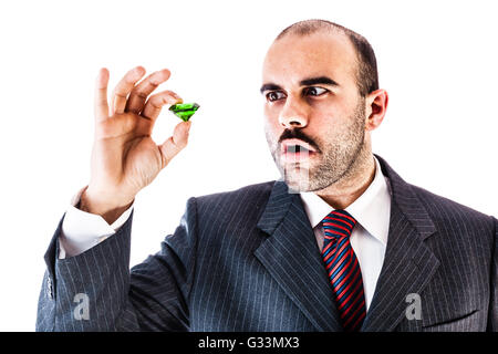 Porträt eines stilvollen Geschäftsmann hält eine große grüne Smaragd isoliert auf einem weißen Hintergrund Stockfoto