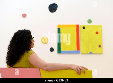 REDAKTIONELLE Nutzung nur Galerie Mitarbeiter Matilde Biagi bei der Installation "Good Vibrations", die Presse-Aussicht auf die Mary Heilmann sieht: Blick auf Bilder-Ausstellung in der Whitechapel Gallery in Ost-London. Stockfoto