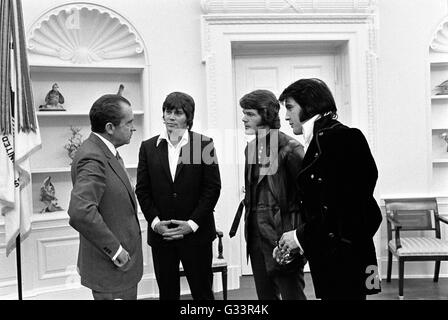 Elvis Presley stellt seine Bandmitglieder US Präsident Richard M. Nixon im Oval Office im Weißen Haus 21. Dezember 1970 in Washington, DC. Das Treffen wurde von Presley, initiiert, Nixon schrieb einen sechs-seitigen Brief mit der Bitte eines Besuchs mit dem Präsidenten und darauf hindeutet, das er ein "Federal Agent-at-Large" im Bureau of Narcotics und gefährlichen Drogen gemacht werden. Stockfoto