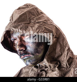 ein Soldat trägt einen Poncho oder Regenmantel und Armee Camouflage Gesicht malen auf einem weißen Hintergrund isoliert Stockfoto