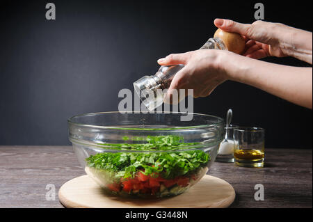 Junge Frau Pfeffer, Salat Schleifen. Stockfoto